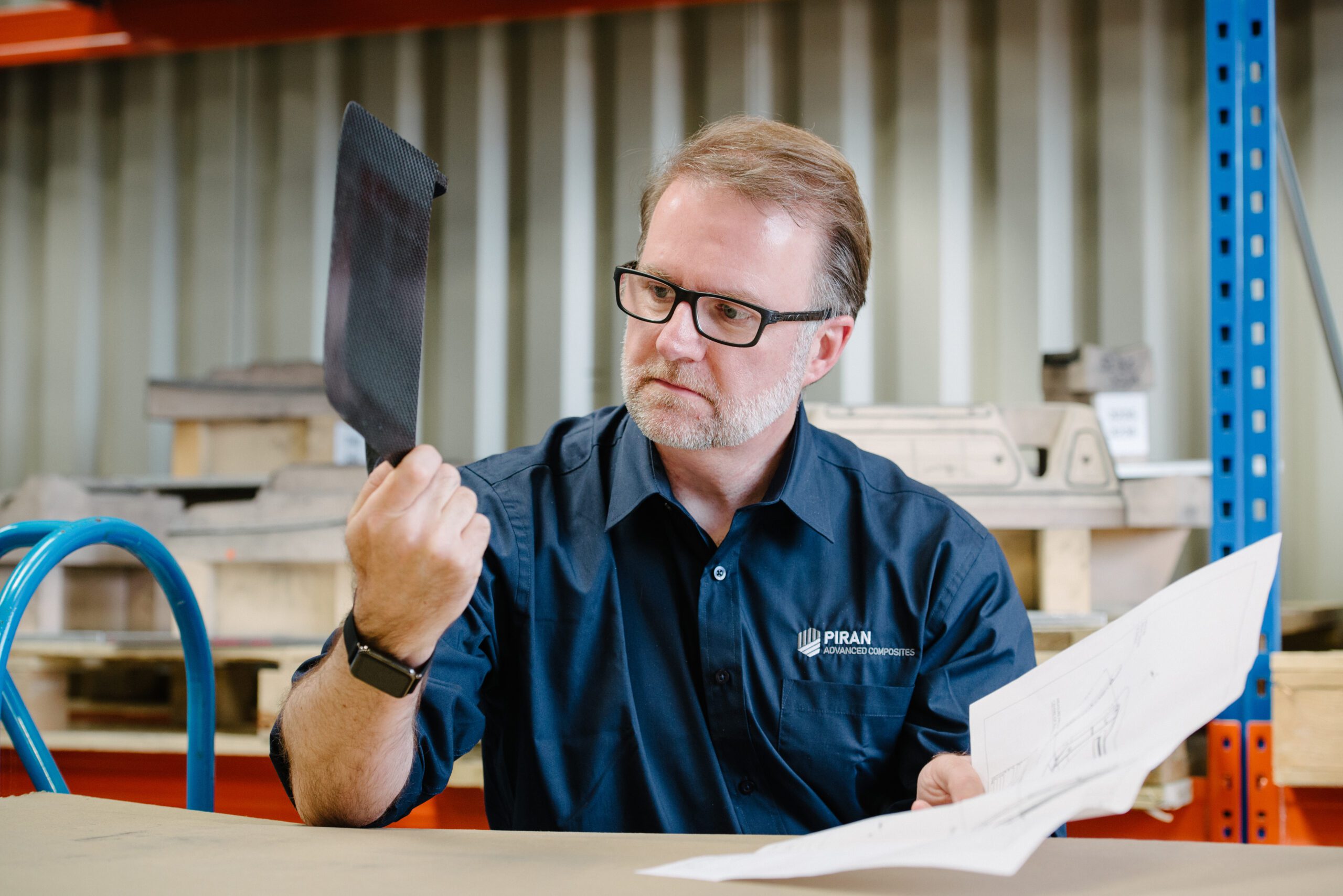 John Armstrong, Design Engineer at Piran Advanced Composites looking at part and drawings.