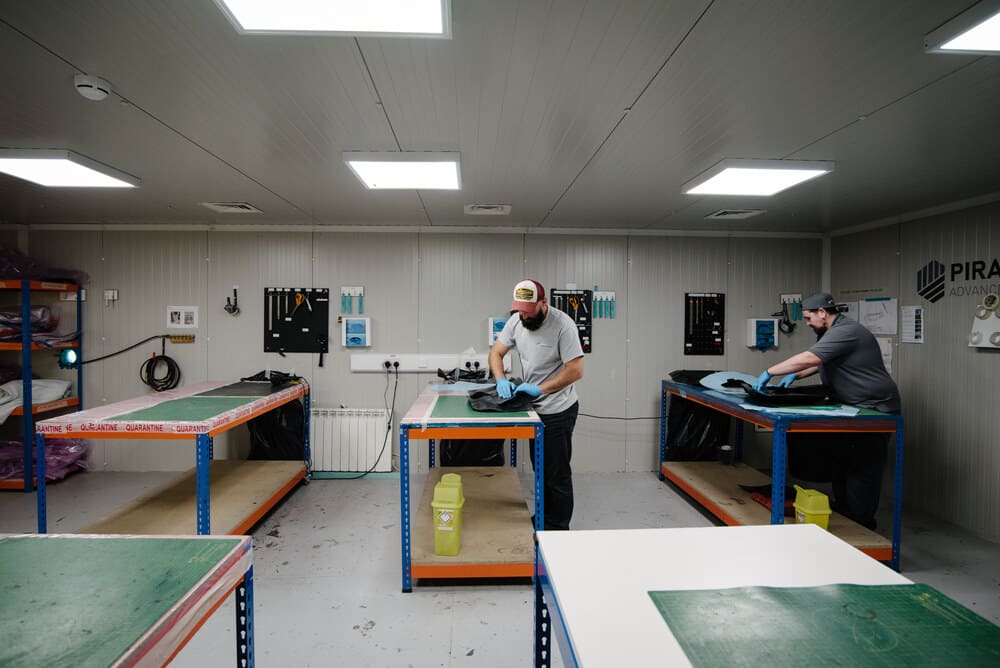 Two members of the Piran team working at worktops all arranged neatly in the Clean Room.