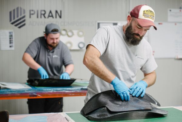 Two men working by hand on carbon fibre parts